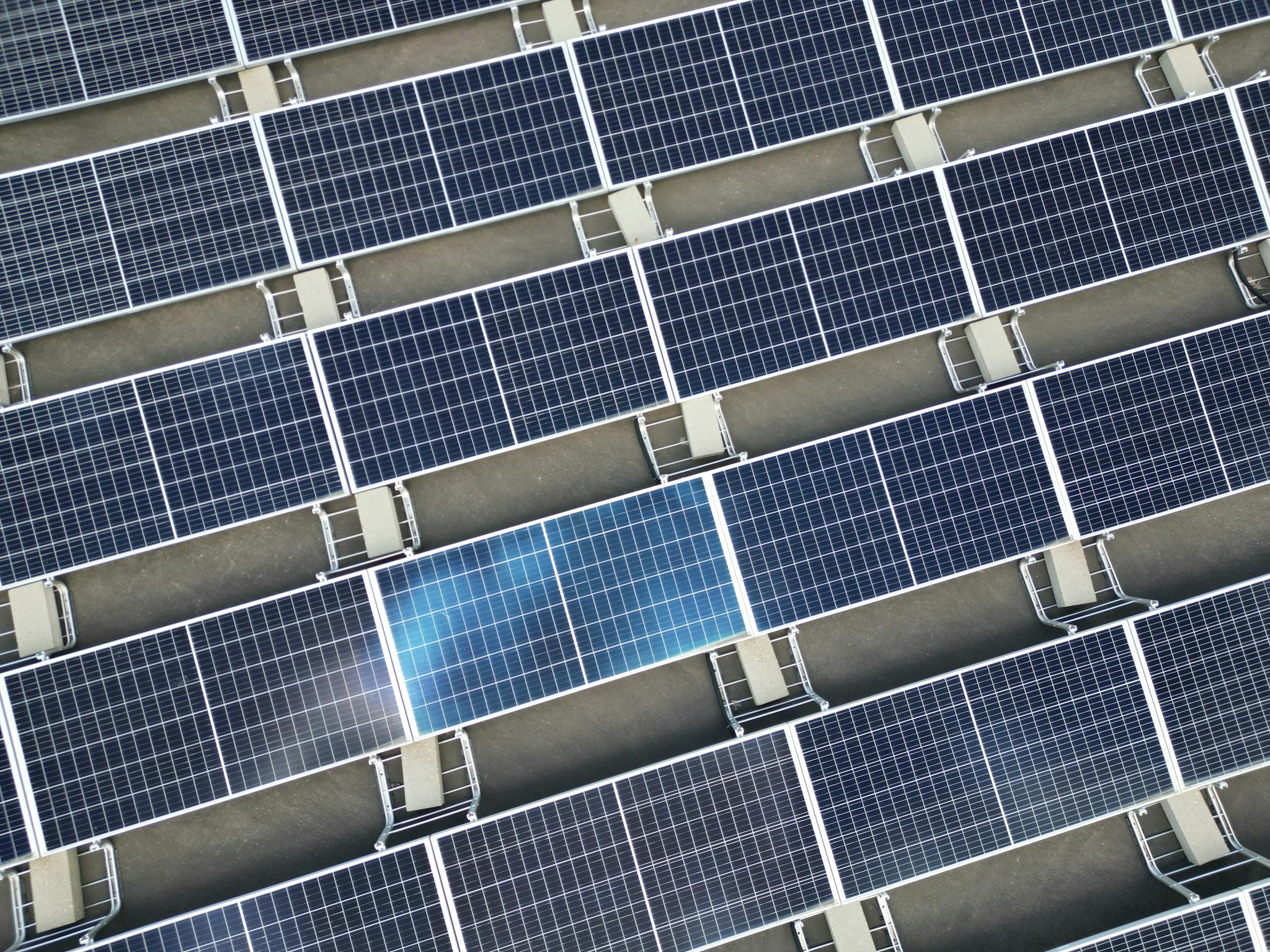 Aerial view of a large array of solar panels on a rooftop, utilizing renewable energy.